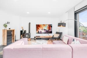 uma sala de estar com um sofá rosa e uma televisão em Dům u Prokopského údolí em Praga
