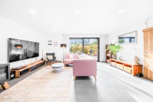a living room with a pink couch and a tv at Dům u Prokopského údolí in Prague