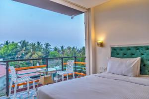 a bedroom with a bed and a balcony with a view at Baga Galaxy in Baga