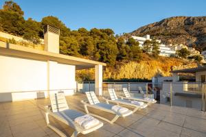 a group of white chairs sitting on a roof at Buccara Altea Beach Villas in Altea