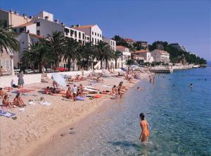 a group of people on a beach in the water at Villa DELFINA 2 in Podgora