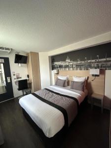 una habitación de hotel con una cama grande. en Logis Cris Hôtel, Lyon Est, en Corbas