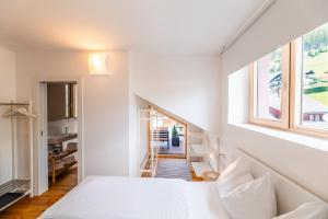 1 dormitorio con cama blanca y ventana en Quercus Appartements contactless check-in en Patergassen