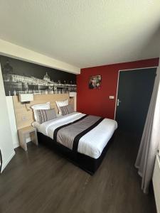 1 dormitorio con 1 cama grande y pared roja en Logis Cris Hôtel, Lyon Est, en Corbas