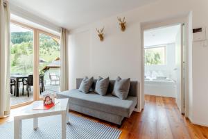 un soggiorno con divano e tavolo di Quercus Appartements contactless check-in a Patergassen