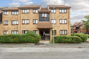 ein Backsteingebäude mit Büschen davor in der Unterkunft Unique Vintage Apartments in Goodmayes