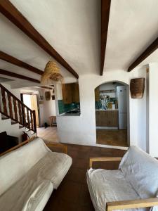 ein Wohnzimmer mit einem Sofa und einer Küche in der Unterkunft Casa Rural con vistas espectaculares in Montejaque