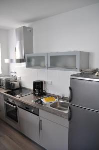 a kitchen with a sink and a stainless steel refrigerator at Zuhause auf Zeit Bielefeld in Bielefeld