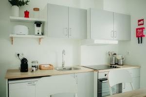 a kitchen with white cabinets and a sink at Belém Tejo - Memória by Local in Lisbon