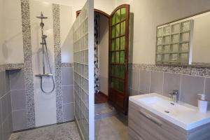 Duas fotografias de uma casa de banho com um lavatório e um espelho. em La rose des vents - proche Paris em Argenteuil