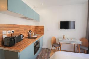 una cucina con un bancone, un lavello e un tavolo di Lille Grand Place - Nice and equipped studio! a Lille