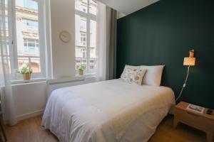 una camera con un letto bianco e una parete verde di Lille Grand Place - Nice and equipped studio! a Lille