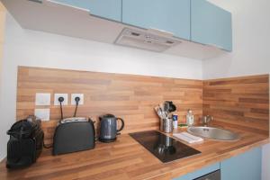 una cucina con piano di lavoro, lavandino e bancone sidx. di Lille Grand Place - Nice and equipped studio! a Lille