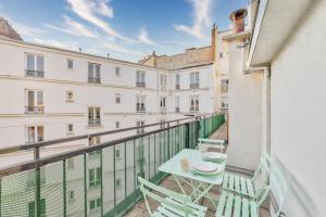 a balcony with a table and chairs on a building at Superbe appartement terrasse 75m Paris in Saint-Mandé