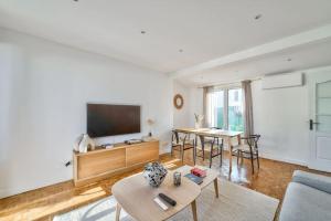 a living room with a tv and a table at Superbe appartement terrasse 75m Paris in Saint-Mandé