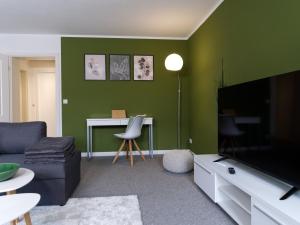 uma sala de estar com um sofá, uma televisão e uma mesa em ThüringenApartments Boulevard XXL 5-7 Personen em Saalfeld