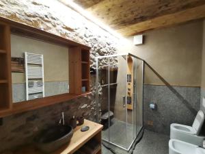 a bathroom with a sink and a glass shower at B&B da Lucia 2 Bormio in Valdisotto
