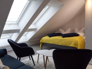 een slaapkamer met een geel bed op een zolder bij ThüringenApartments Boulevard XXL 5-7 Personen in Saalfeld