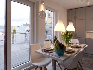 a dining room with a table and a large window at ThüringenApartments Boulevard XXL 5-7 Personen in Saalfeld