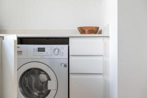 - une buanderie blanche avec lave-linge et sèche-linge dans l'établissement Belgravia Apartment 22, à Londres