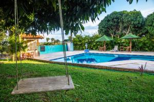 een schommel in het gras naast een zwembad bij POUSADA NEVOAR in Guaraciaba do Norte