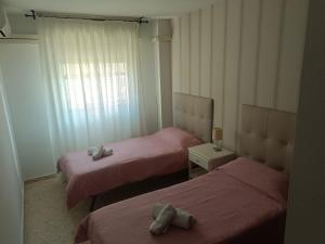 een kamer met 2 bedden en een raam bij Piso para 6 junto al acueducto. A pasos del centro in Sevilla