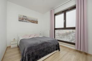 een slaapkamer met een bed en een groot raam bij Apartments Warsaw CityLink by Renters in Warschau