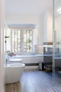 a white bathroom with a tub and a sink at Villa Bice in Bergeggi