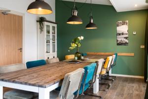 a dining room with a wooden table and chairs at De Johanneshoeve in Westerhaar-Vriezenveensewijk