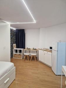 Il comprend une cuisine équipée d'un réfrigérateur et d'une table avec des chaises. dans l'établissement Modular Suites Alfonso Gómez, à Madrid