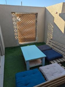 een patio met een tafel, een bank en een hek bij Paula's corner in Beʼer Ora