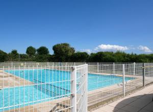 a large swimming pool with a fence around it at Zeepolder I 3 in De Haan
