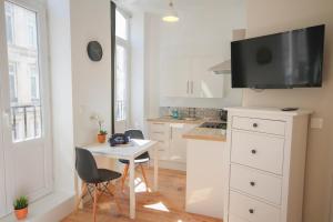 a kitchen with a table and a tv on a wall at Lille centre- Nice Studio in Lille
