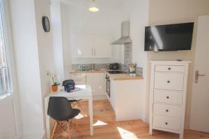 a small kitchen with a table and a tv at Lille centre- Nice Studio in Lille