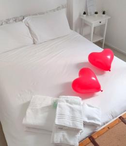 due cuori rossi seduti su un letto con asciugamani di B&b Sedilequattro a Castellaneta