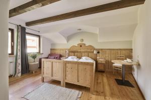 - une chambre avec un grand lit et une table dans l'établissement Haus Tirol, à Molini di Tures