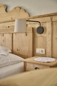 een slaapkamer met een bed en een lamp op een tafel bij Haus Tirol in Molini di Tures