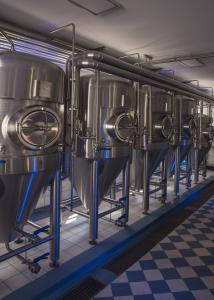 une rangée de cuves à vin dans une brasserie dans l'établissement Bierhotel - Hotel & Brauereigasthof Schneider, à Essing