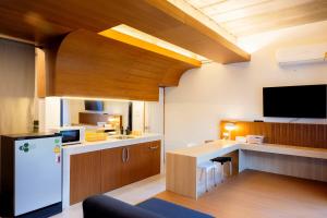 a kitchen with a refrigerator and a desk with a tv at Karpenter Lampang in Lampang