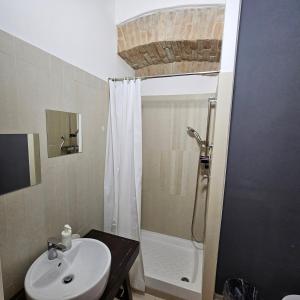 a bathroom with a sink and a shower with a shower curtain at ESSENTIAL ROOM & PARKING in Centro Città con Parcheggio Privato e WIFI in Potenza