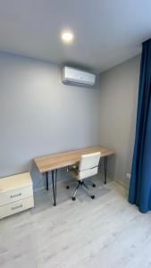 an office with a desk with a chair and a blue curtain at FlatService Просторі апартаменти в сучасному ЖК Parkland in Kyiv