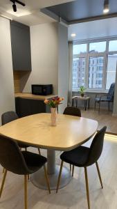 a table in a room with chairs and a kitchen at FlatService Просторі апартаменти в сучасному ЖК Parkland in Kyiv