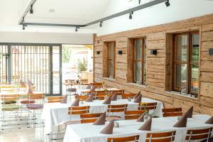 un restaurant avec des tables blanches, des chaises et des fenêtres dans l'établissement Bierhotel - Hotel & Brauereigasthof Schneider, à Essing