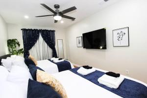 a bedroom with two beds and a flat screen tv at NEW! 2-Bedroom Fontana Guest House near Speedway in Fontana
