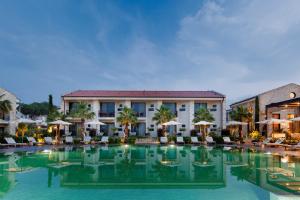 a hotel with a large pool with chairs and umbrellas at Palaia Hotel Datça in Datca