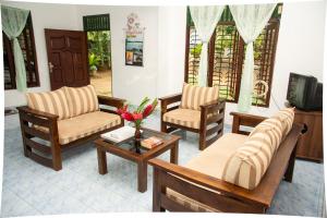 a living room with two chairs and a coffee table at Mango villa in Unawatuna