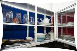 a kitchen cabinet filled with dishes and glasses at Mango villa in Unawatuna