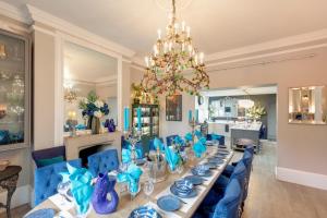a dining room with a long table and blue chairs at The Georgian Villa in Ross on Wye
