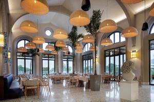 a dining room with tables and chairs and chandeliers at Palaia Hotel Datça in Datca