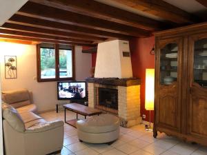 uma sala de estar com um sofá e uma lareira em La Fermette Aux Lamas em Savigny-Lévescault